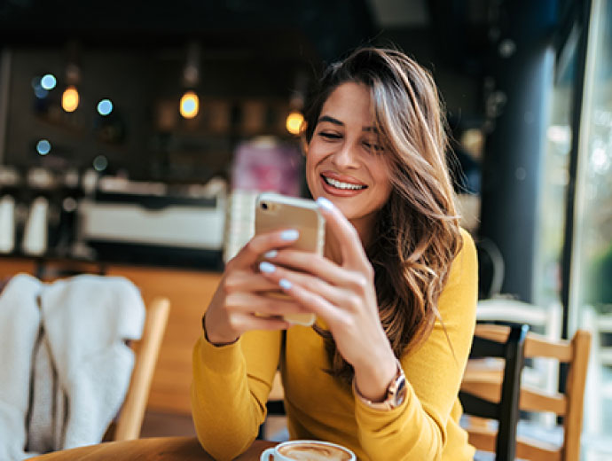 Young lady using her smartphone in a restaurant